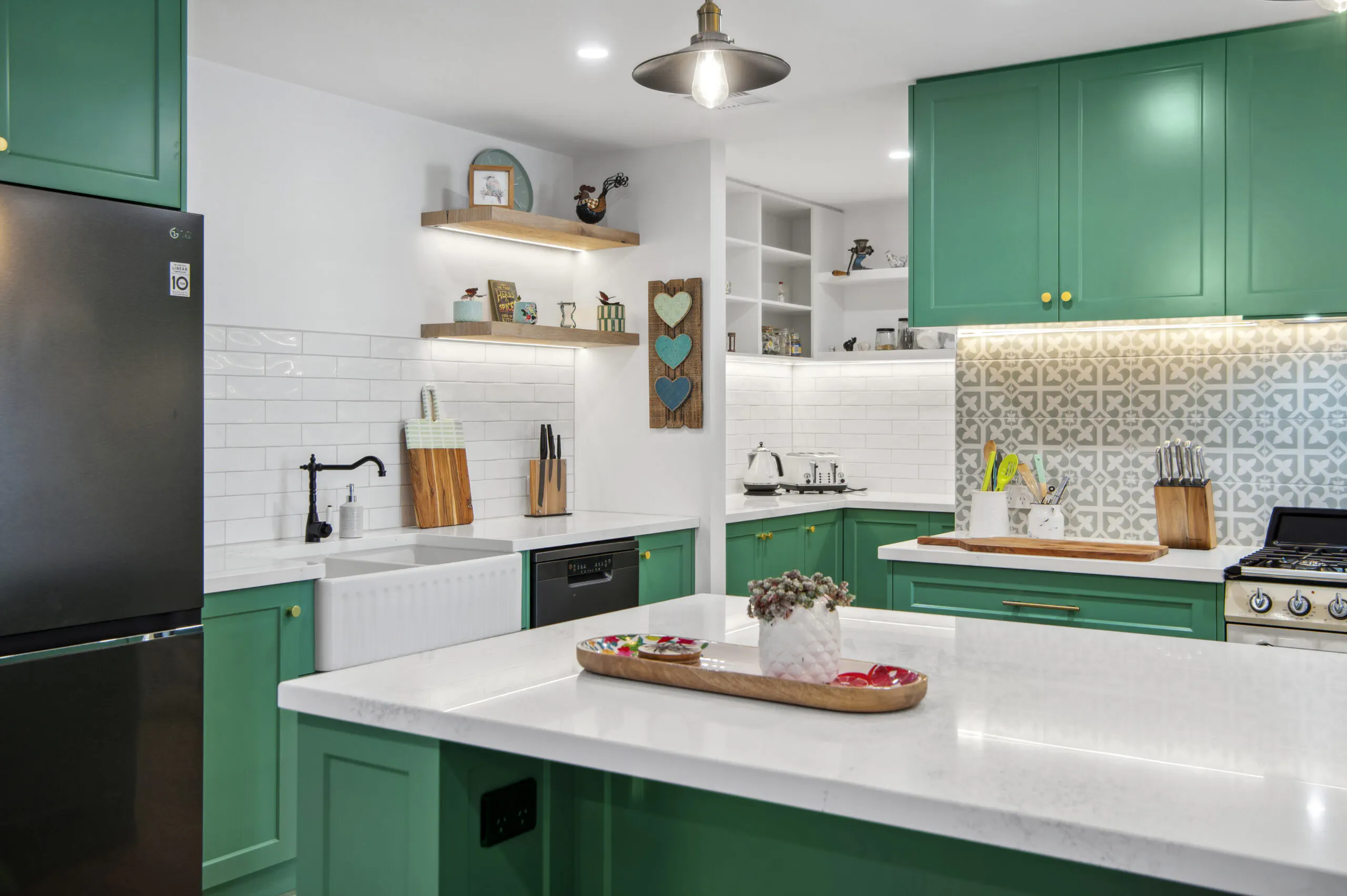 Green kitchen with a farmhouse sink and open shelving