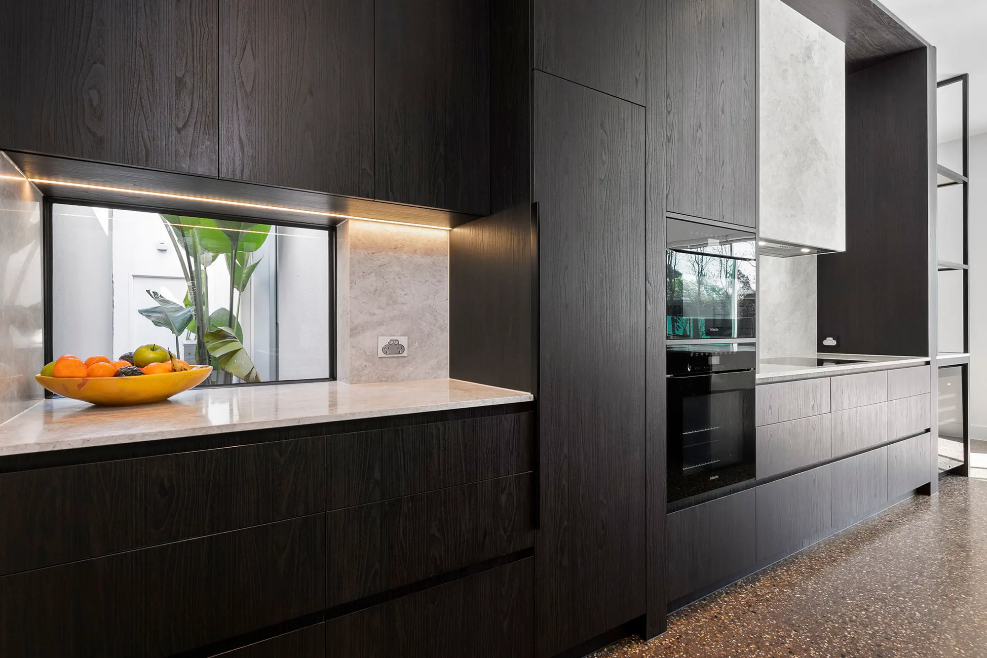 Dark oak kitchen with a lit stone splashback