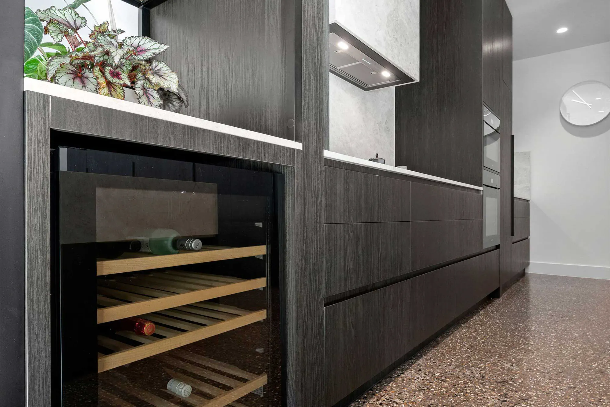 Built-in wine fridge set into dark timber cabinetry